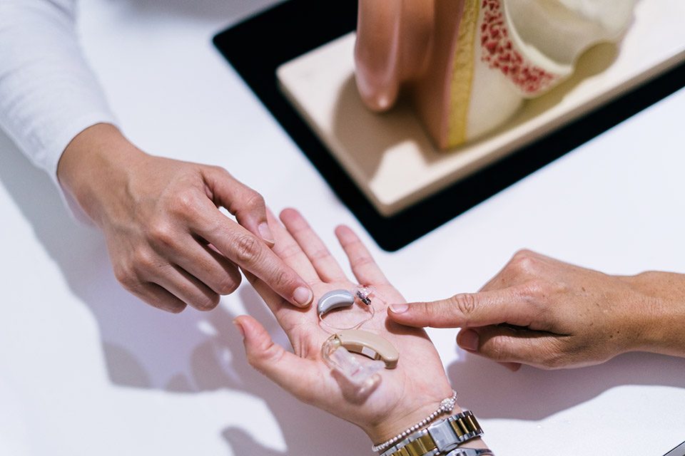 Close-up of female doctor's hands showing hearing aids