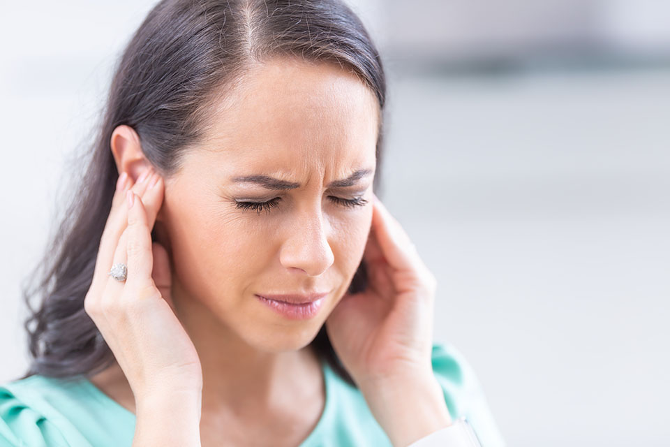 Woman with hands in her ears